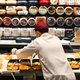 grocery store worker arranges cheese